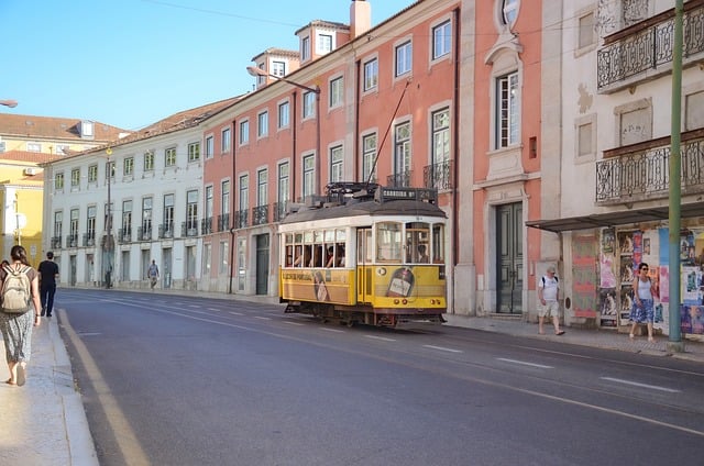 Cobblestone street in Lisbon with historic trams and colorful buildings