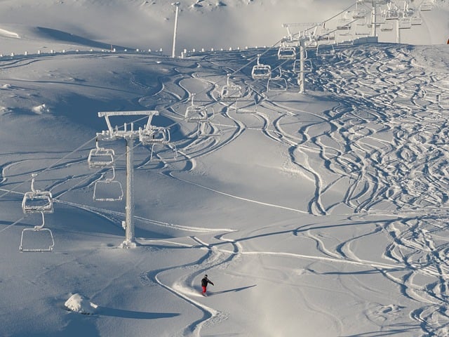 Skiers enjoying powder on a groomed slope at Vail Mountain
